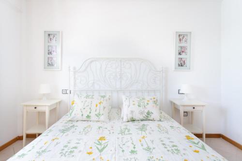 1 Schlafzimmer mit einem weißen Bett und 2 Tischen in der Unterkunft Luxury Apartment in Costa Adeje in Adeje