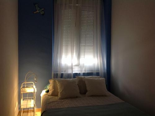 - une chambre avec un lit en face d'une fenêtre dans l'établissement La casa del dibujante, à Cadix