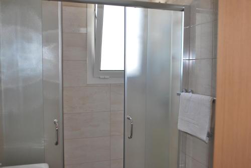 una doccia con porta in vetro in bagno di Sofo Hotel Dhermi a Dhërmi