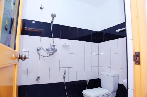 a black and white bathroom with a toilet and a shower at Sajana Ocean Hill in Mirissa