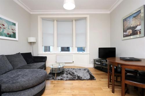 a living room with a couch and a table at Dreamhouse Apartments Glasgow St Vincent Street in Glasgow