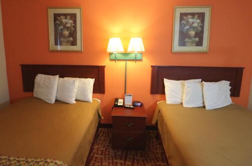 two beds in a hotel room with orange walls at Jefferson Inn Dandridge in Dandridge