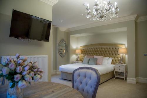 um quarto com uma cama, uma televisão e uma mesa em Winckley Stays em Preston