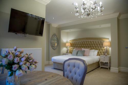 een slaapkamer met een bed en een televisie en een tafel bij Winckley Stays in Preston