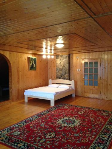 a bedroom with a bed in a room with a rug at Usadba Tatarchik in Tatariv