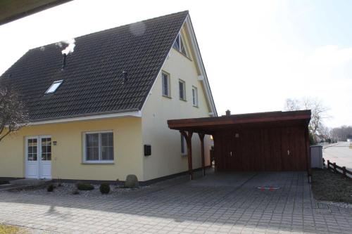 a yellow house with a garage and a brown roof at Fewo Sanddorn_BOBE in Ostseebad Karlshagen