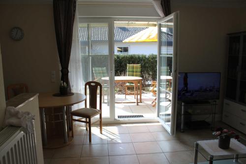 a living room with a door open to a patio at Fewo Sanddorn_BOBE in Ostseebad Karlshagen