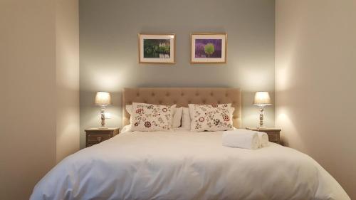 a bedroom with a large white bed with two lamps at Chez Jacqueline in Tours