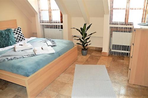 1 dormitorio con 1 cama con 2 toallas en Downtown Apartments Superior, en Győr