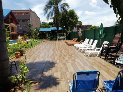 a patio with white chairs and a basketball hoop at Hotel Amayal in Puerto Iguazú