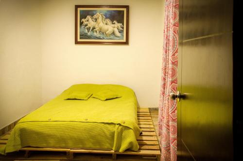 ein Bett in einem Schlafzimmer mit einem Bild von Pferden an der Wand in der Unterkunft Bababuy Hostel in Bogotá