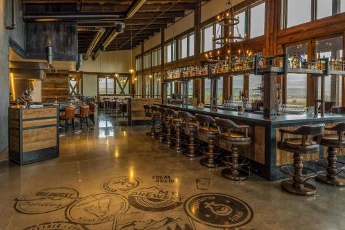 a bar with a bunch of bar stools in a room at Sage Lodge in Pray