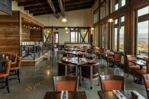 un restaurant avec des tables, des chaises et des fenêtres dans l'établissement Sage Lodge, à Pray