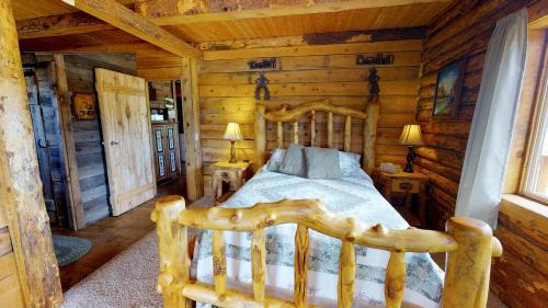 a bedroom with a bed in a log cabin at Canyon View Family Cabin, Deck, TV Room, Games, BBQ, Campfire in Monticello