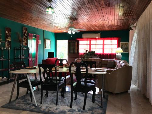 uma sala de jantar com uma mesa e um sofá em Posada Nativa Trinsan Campestre em San Andrés