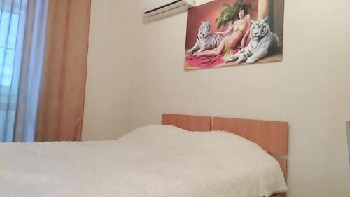 ペンザにあるApartment Na Rakhmaninova 5の白いシーツと壁に絵が描かれたベッド