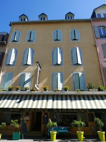 a large building with windows and a awning at Hôtel Saint Vincent in Bagnères-de-Bigorre