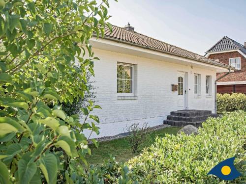 ein weißes Haus mit einer Veranda und einigen Büschen in der Unterkunft Ferienwohnung (-haus) Whg. 02 Gartenstraße in Bansin