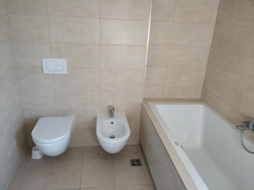 La salle de bains est pourvue de toilettes, d'une baignoire et d'un lavabo. dans l'établissement Apartment Morski cvet, à Koper