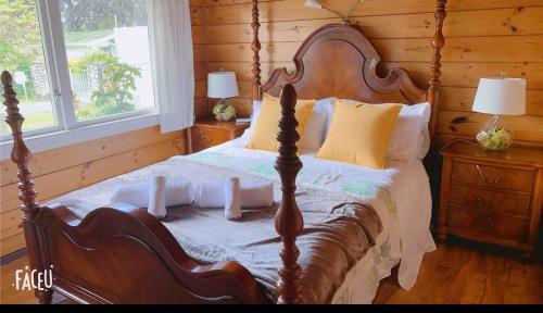 een houten slaapkamer met een bed met een houten muur bij Classical Lockwood house nearby the stream in Rotorua