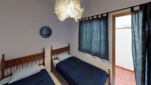 a bedroom with two beds and a window at Mi Posadita - Los Roques in Playa de San Juan