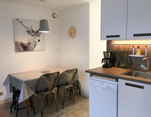 une cuisine avec une table, des chaises et un évier dans l'établissement Beau Site, à Villard-de-Lans