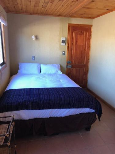 a bedroom with a large bed with a wooden ceiling at Delfín Apart in Pichilemu