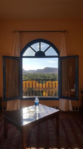 a room with a window with a table and a view at Maison D'hotes Sahara in Aoufous