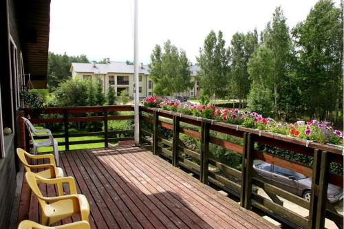 two chairs sitting on a wooden deck with flowers at Rähni Maja in Põlva