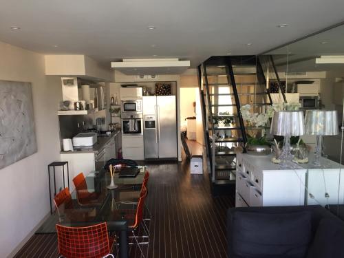 Il comprend une cuisine et une salle à manger avec une table et un réfrigérateur. dans l'établissement Marines de Cogolin, à Cogolin