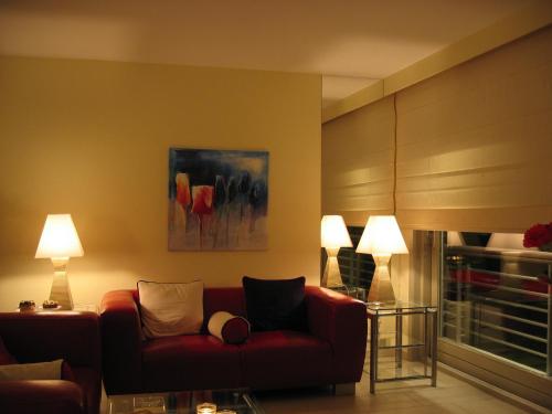 a living room with a red couch and two lamps at Residentie Albert-1, app.202, Zeelaan 214 in De Panne