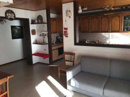sala de estar con sofá y cocina en residenza in zona Pontedilegno T02034, en Villa dʼAllegno