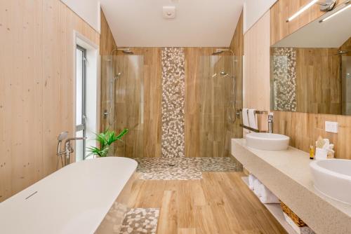 y baño con bañera, 2 lavabos y ducha. en The Sands Hotel Hokianga, en Opononi