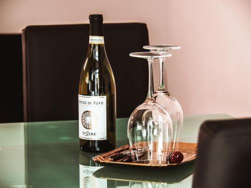 een fles wijn en een glas op een tafel bij Appartamento Magnolia in Turijn
