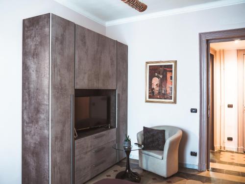 ein Wohnzimmer mit einem TV und einem Stuhl in der Unterkunft Appartamento Magnolia in Turin