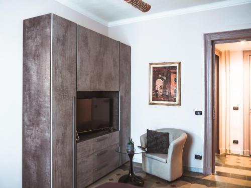 sala de estar con TV y silla en Appartamento Magnolia, en Turín