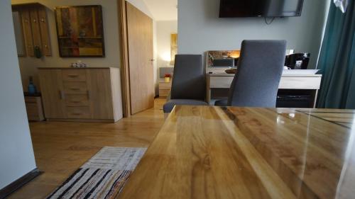 a living room with a wooden table and a kitchen at Apartamenty Efekt 72 in Gdynia