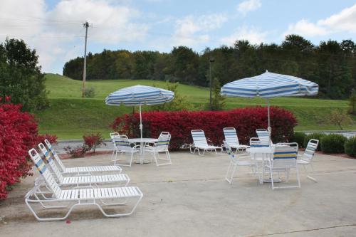 a group of chairs and tables with umbrellas at Best Western Richland Inn Mansfield in Mansfield