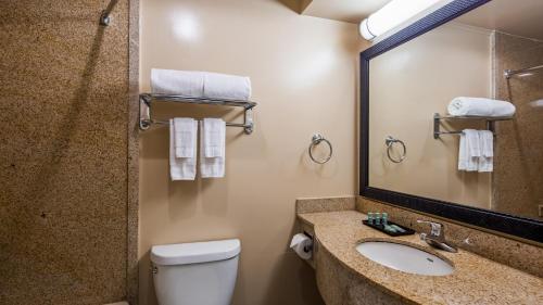 a bathroom with a toilet and a sink and a mirror at Best Western Bennington in Bennington