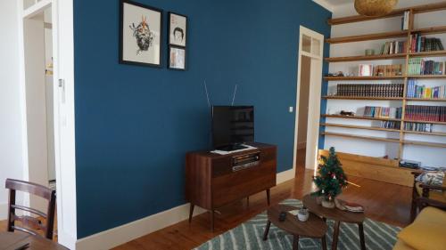 a living room with blue walls and a christmas tree on a table at Casa Pé da Cabra in Coimbra