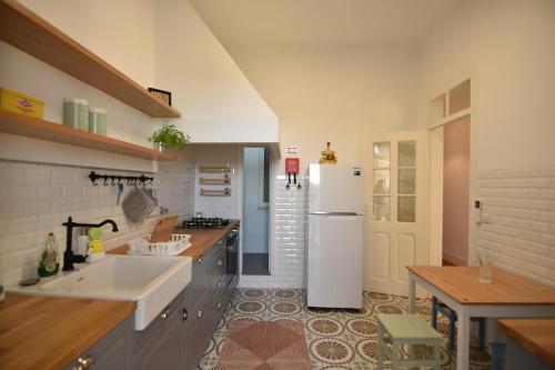 a kitchen with a white refrigerator and a sink at Casa Pé da Cabra in Coimbra