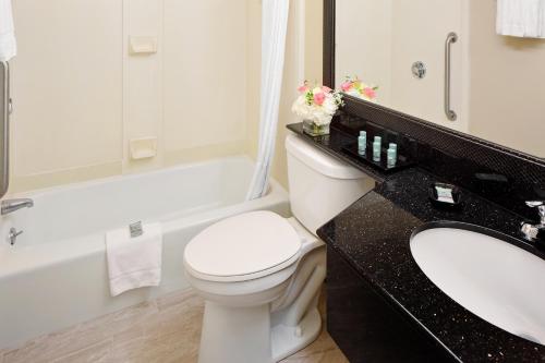 a bathroom with a toilet and a sink and a tub at Best Western Bennington in Bennington