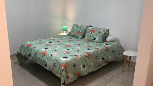 a bedroom with a bed with a green comforter at Sunset house in Los Realejos