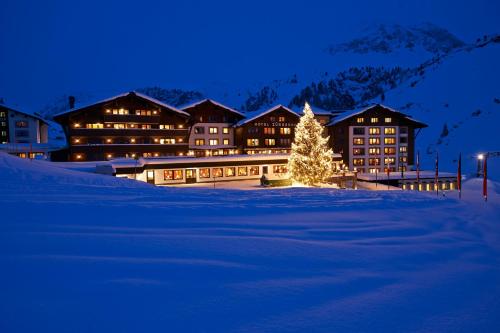 a christmas tree in front of a lodge in the snow at Hotel Zürserhof in Zürs am Arlberg