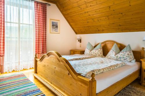 a bedroom with a wooden bed and a large window at Bio Bauernhof Schoberhof in Sankt Andrä im Lungau