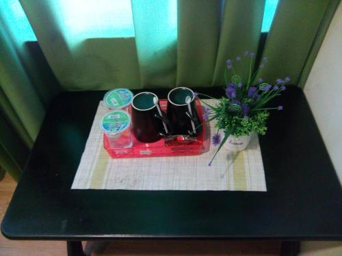 a black table with a tray and a vase of flowers at BINKHALED HOTEL in Kota Tinggi