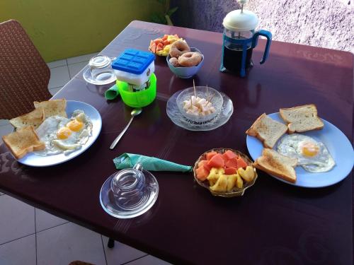 a purple table with plates of breakfast food on it at pulau weh sabang marifi in Paya