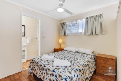 1 dormitorio con cama y ventana en Charters Towers Tourist Park, en Charters Towers