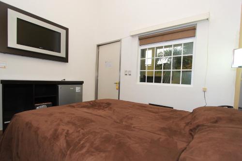 a bedroom with a bed and a flat screen tv at Hotel 5 inn in Silao