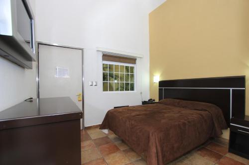 a bedroom with a bed and a large window at Hotel 5 inn in Silao